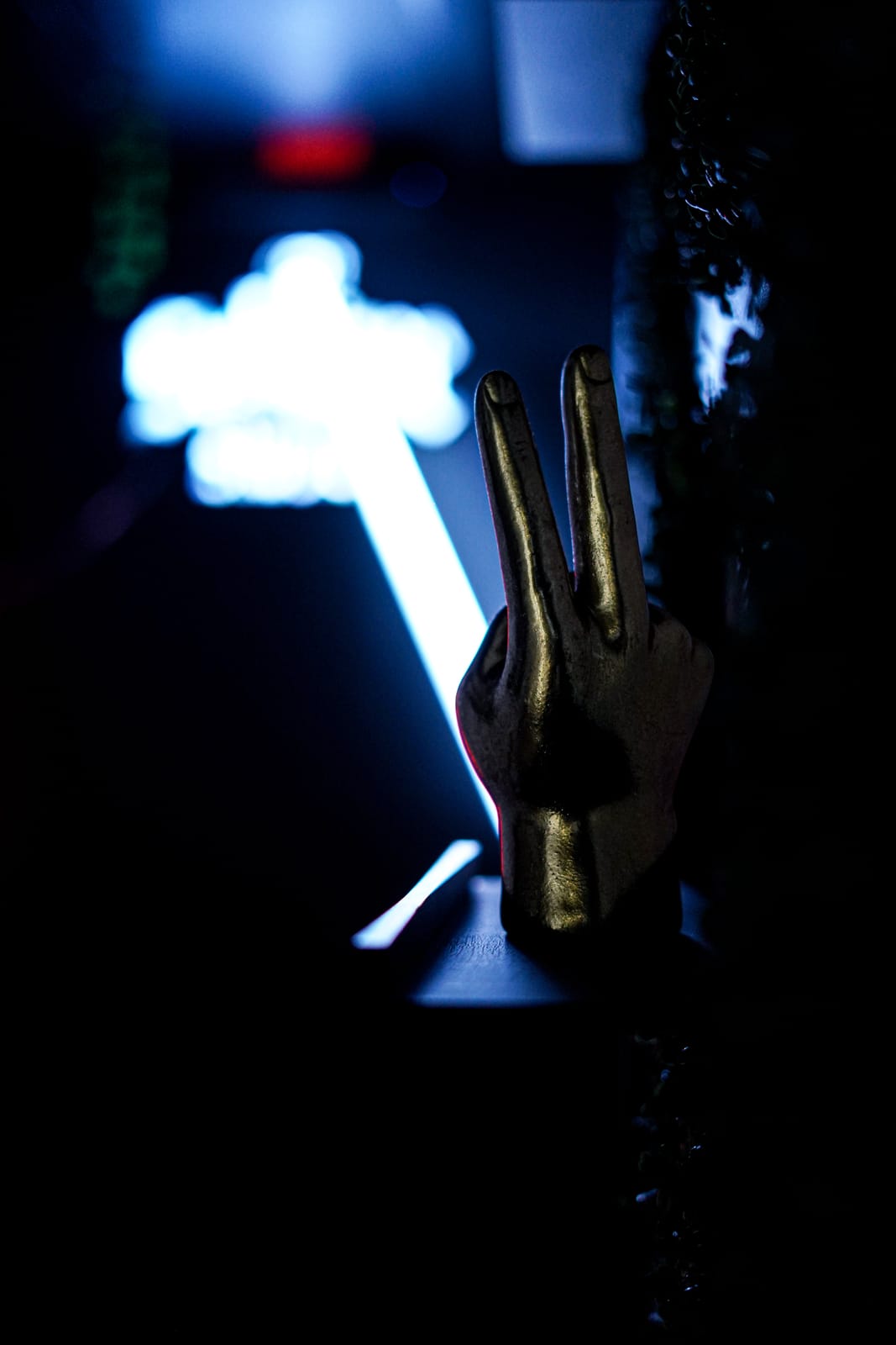 Gold hand sculpture under a neon sign, shot in the studio